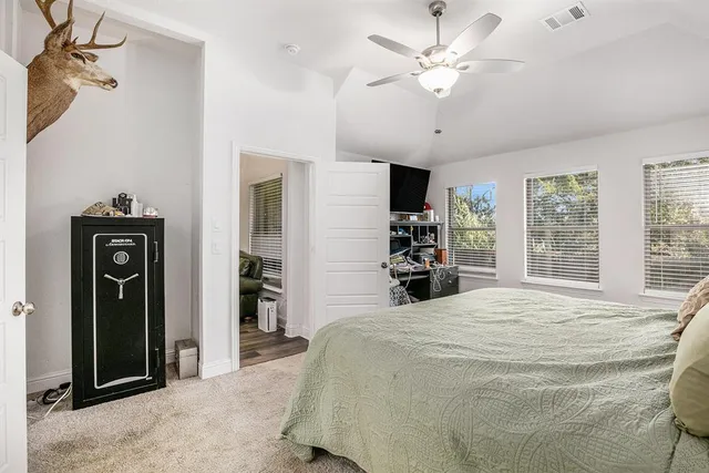 a large white bed in a spacious bedroom and a chandelier