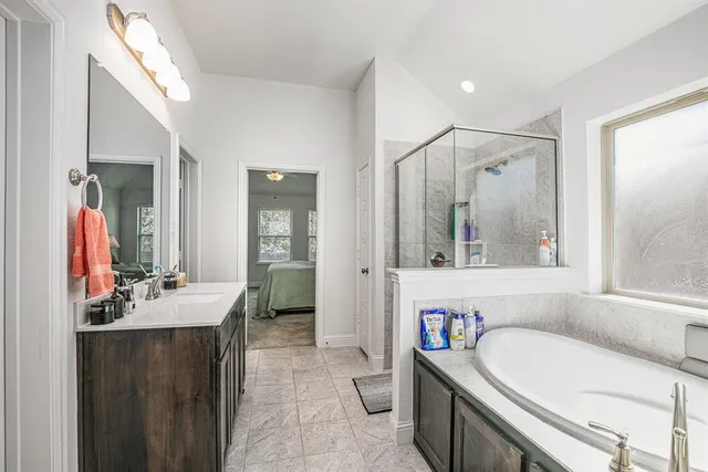 a bathroom with a double vanity sink mirror and bathtub