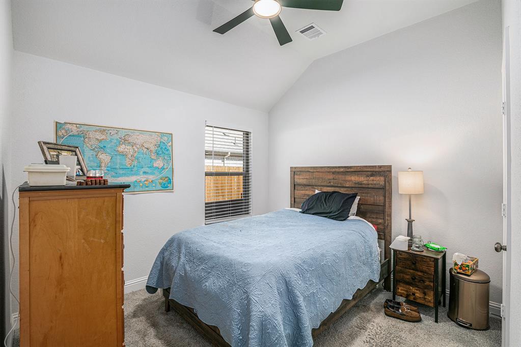 417 Elyse Road Keene, TX 76059 - Photo 27 of 34 a bedroom with a bed and a chandelier