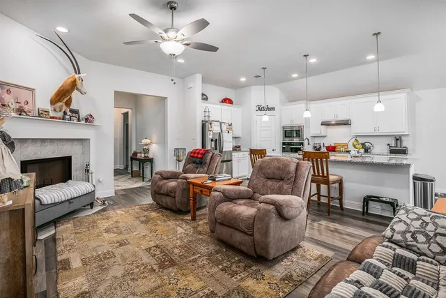 a living room with furniture fireplace and kitchen view