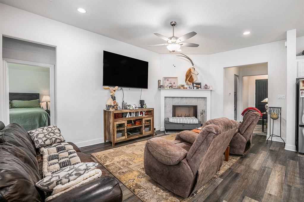 417 Elyse Road Keene, TX 76059 - Photo 10 of 34 a living room with furniture a flat screen tv and a fireplace