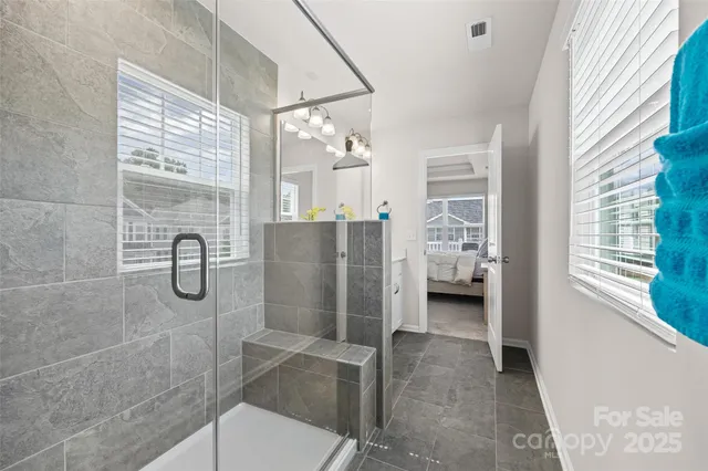 a bathroom with a glass shower door and a window