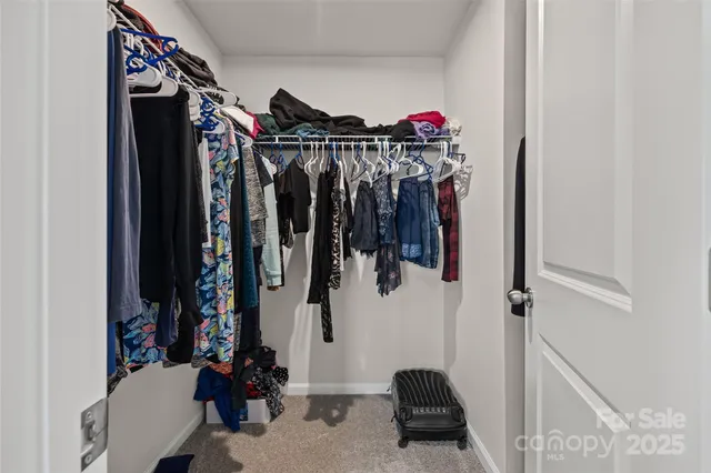 a view of walk in closet with clothes and shoes