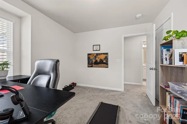 a view of a workspace with furniture and a window