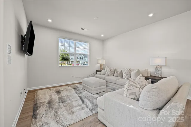 a living room with furniture a flat screen tv and a window