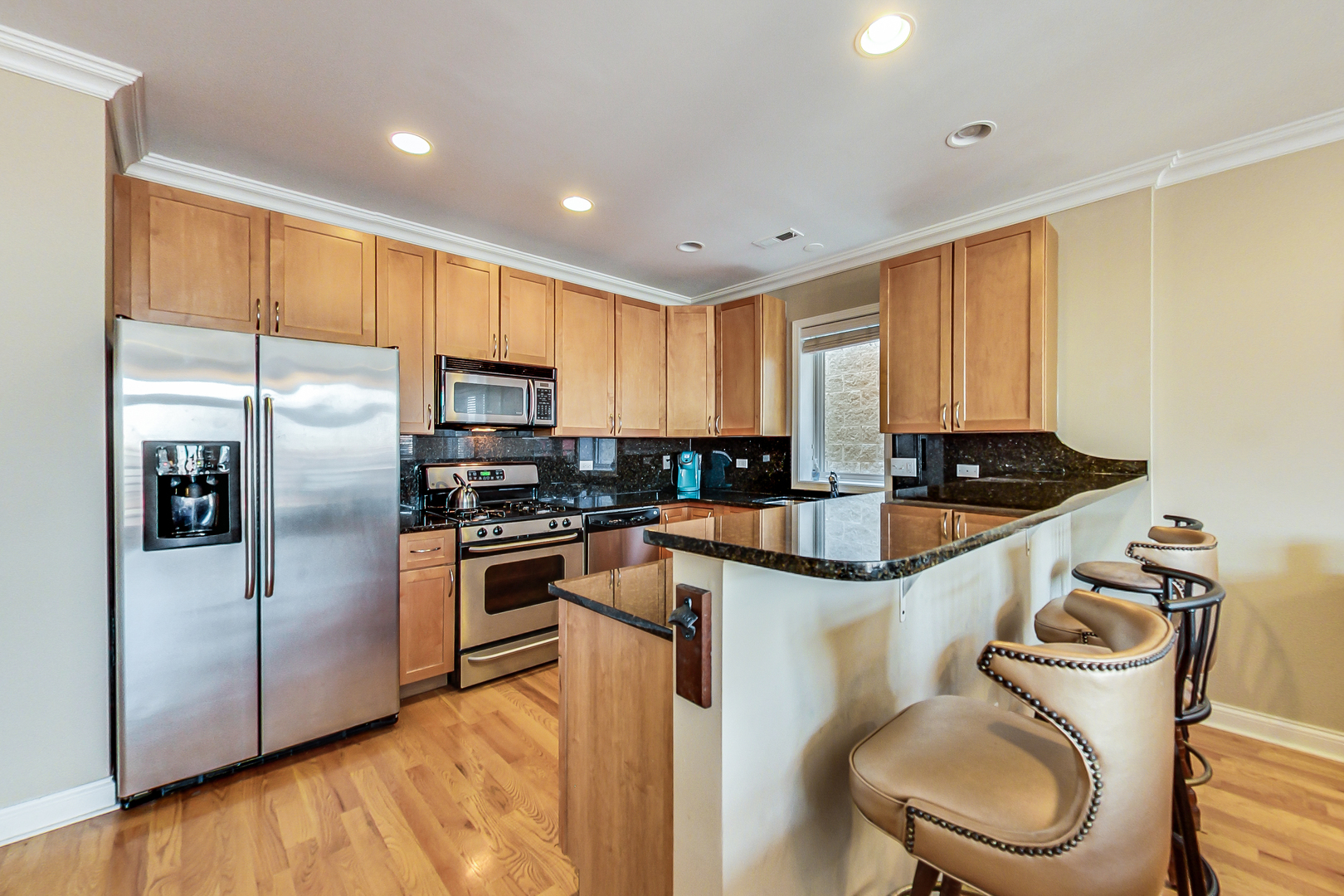 2353 West Harrison Street, Unit 4 Chicago, IL 60612 - Photo 5 of 25 a kitchen with granite countertop stainless steel appliances cabinets a sink and a large window