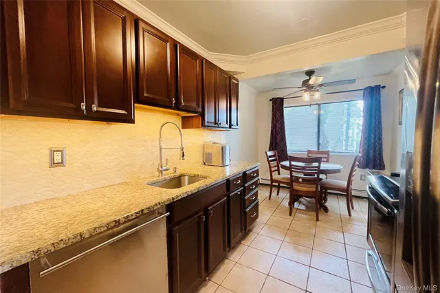 a kitchen with stainless steel appliances granite countertop sink stove top oven table and chairs