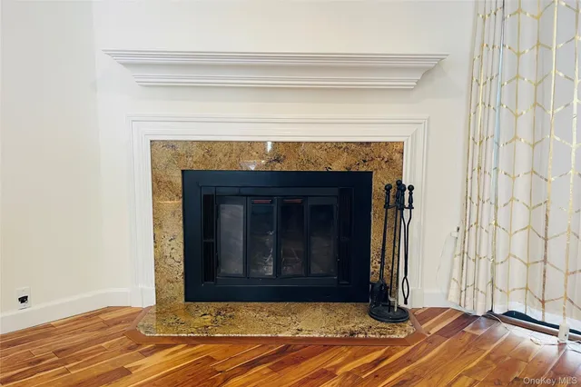 a view of a livingroom with wooden floor and a fireplace