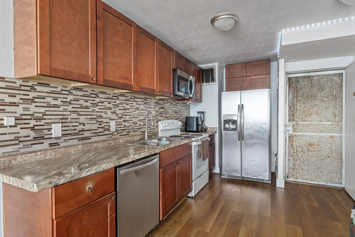 111 Kahului Beach Road, Unit A326 Kahului, HI 96732 - Photo 11 of 43 a kitchen with stainless steel appliances granite countertop a sink a refrigerator and wooden cabinets