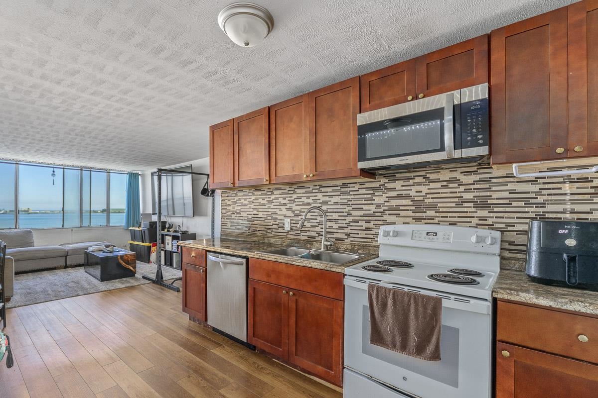111 Kahului Beach Road, Unit A326 Kahului, HI 96732 - Photo 12 of 43 a kitchen with stainless steel appliances wooden cabinets and a stove top oven