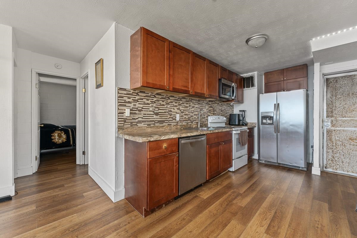 111 Kahului Beach Road, Unit A326 Kahului, HI 96732 - Photo 16 of 43 a kitchen with stainless steel appliances granite countertop a refrigerator a stove and a wooden floors