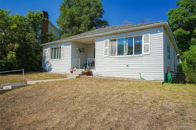 a view of a house with backyard and trees