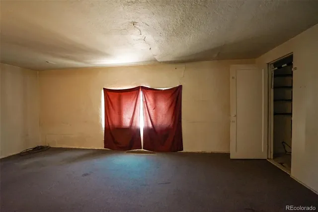 an empty room with windows and closet