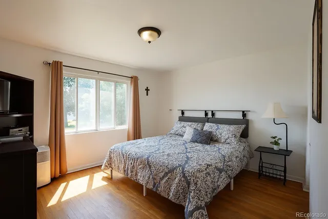 a bedroom with a bed and wooden floor