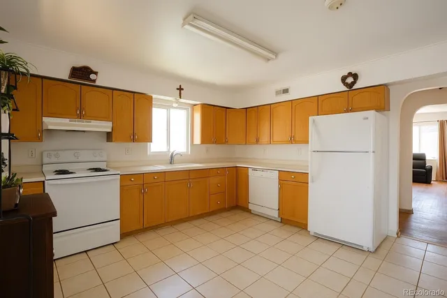 a kitchen with granite countertop cabinets and white appliances