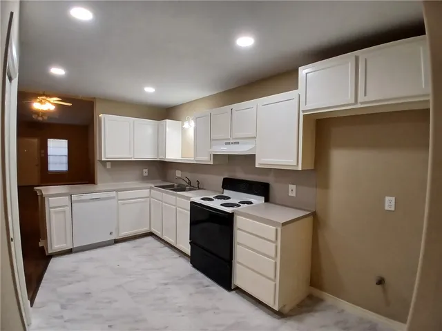 a kitchen with a sink stove and cabinets