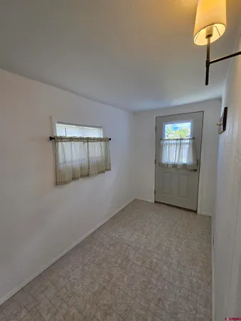 an empty room with windows and cabinet