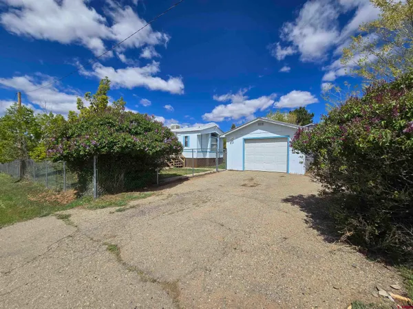 a view of a house with a yard and a garage
