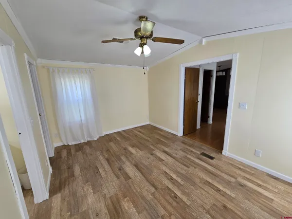 a view of a livingroom with wooden floor and a ceiling fan