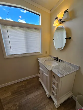 a bathroom with a granite countertop double vanity and a mirror