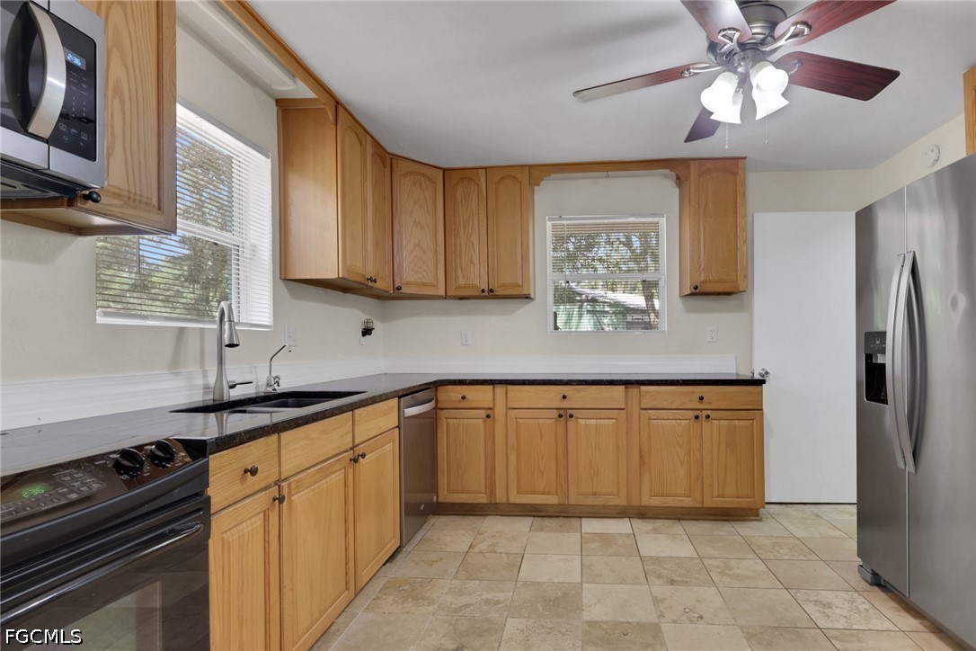 2431 Lippincott Road Alva, FL 33920 - Photo 12 of 43 a kitchen with stainless steel appliances granite countertop a sink a stove a refrigerator cabinets and a window