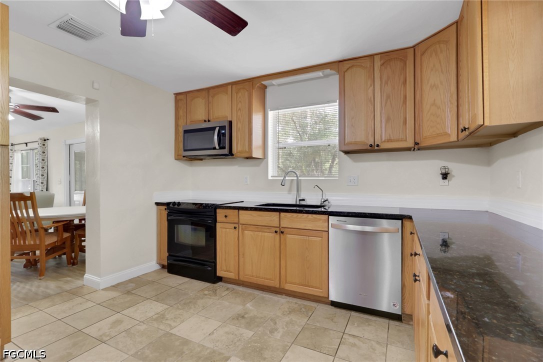 2431 Lippincott Road Alva, FL 33920 - Photo 13 of 43 a kitchen with stainless steel appliances granite countertop a stove sink and cabinets