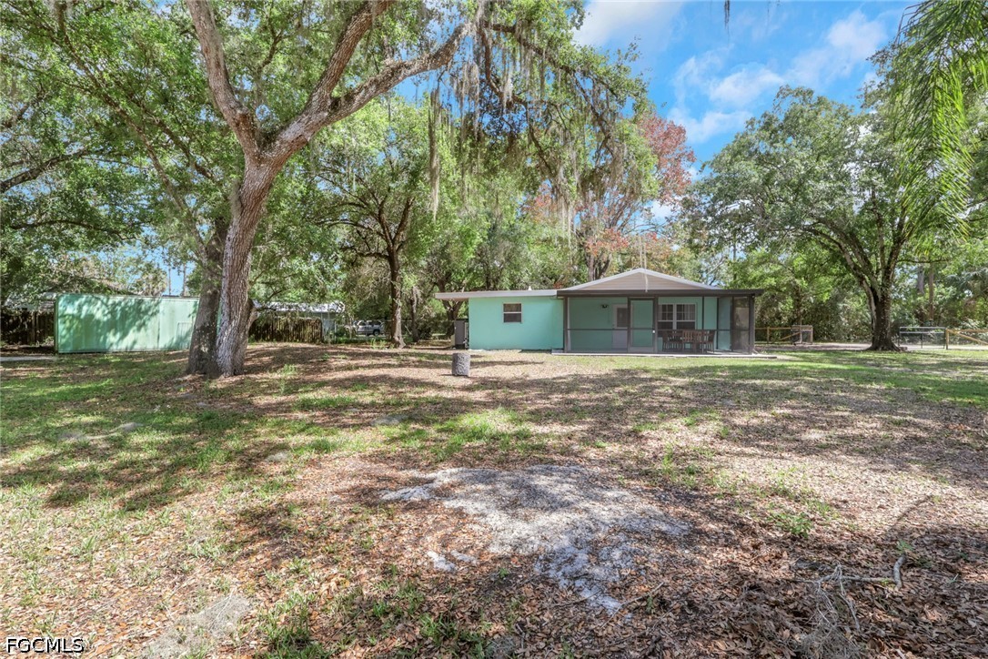 2431 Lippincott Road Alva, FL 33920 - Photo 36 of 43 a backyard of a house with large trees and outdoor seating
