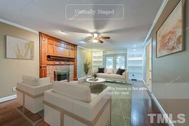 8335 Morgans Way Raleigh, NC 27613 - Photo 2 of 23 a living room with furniture a fireplace and a flat screen tv