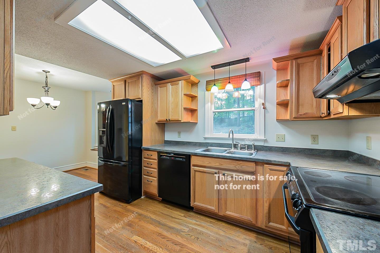 8335 Morgans Way Raleigh, NC 27613 - Photo 15 of 23 a kitchen with stainless steel appliances granite countertop a refrigerator a sink dishwasher a stove and white countertops with wooden floor