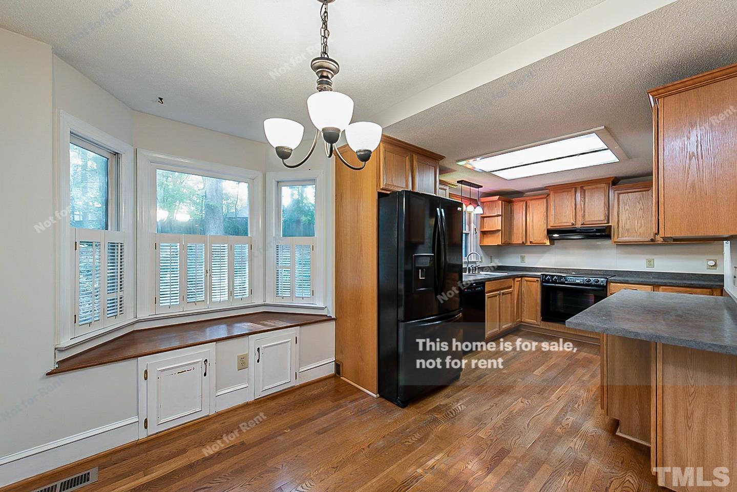 8335 Morgans Way Raleigh, NC 27613 - Photo 16 of 23 a large kitchen with stainless steel appliances granite countertop a refrigerator a sink dishwasher a stove and white cabinets with wooden floor