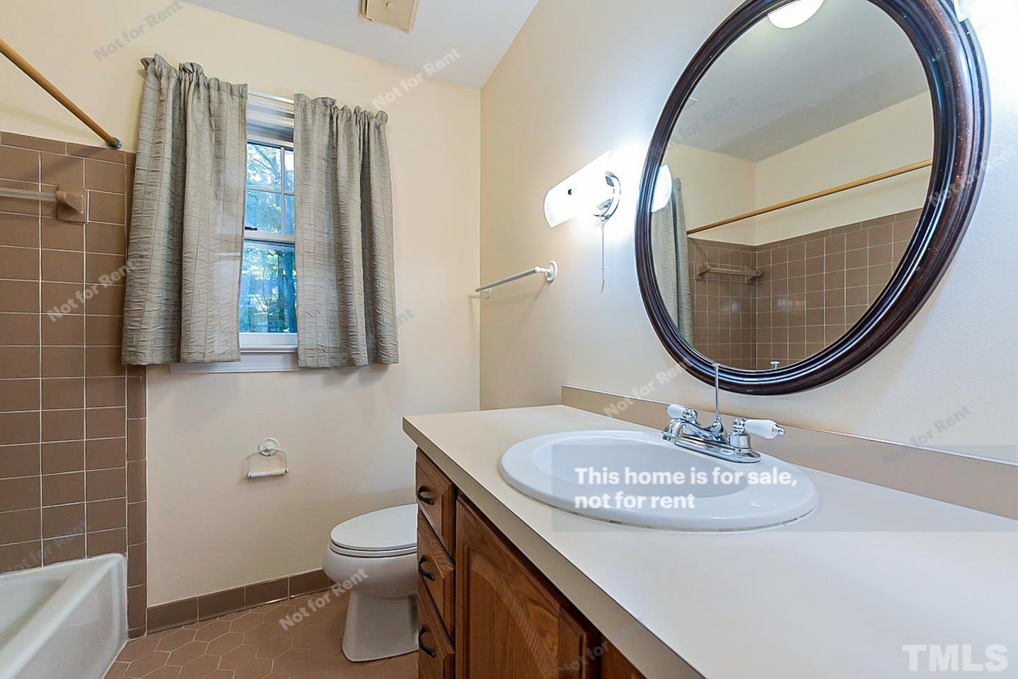 8335 Morgans Way Raleigh, NC 27613 - Photo 20 of 23 a bathroom with a sink a mirror and a toilet