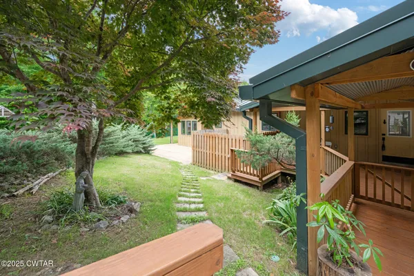 a view of a house with backyard and trees