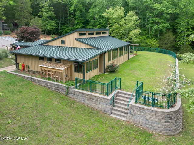 a view of a backyard with large trees and wooden fence