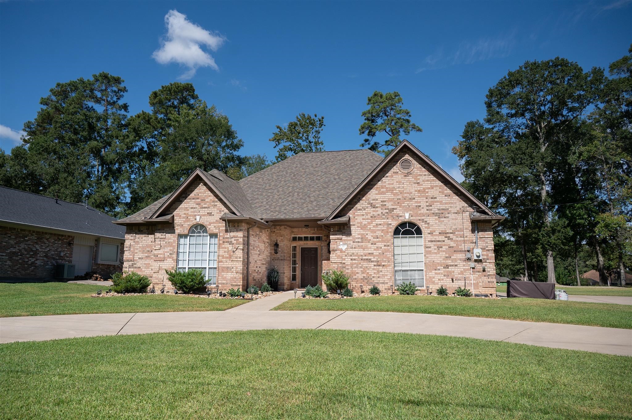 77 Panorama Drive Conroe, TX 77304 - Photo 2 of 49 a view of a house next to a yard with plants and large trees