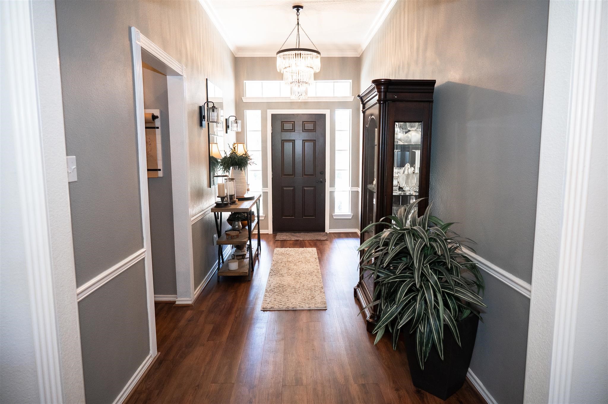 77 Panorama Drive Conroe, TX 77304 - Photo 8 of 49 a hallway with wooden floor windows and a chandelier