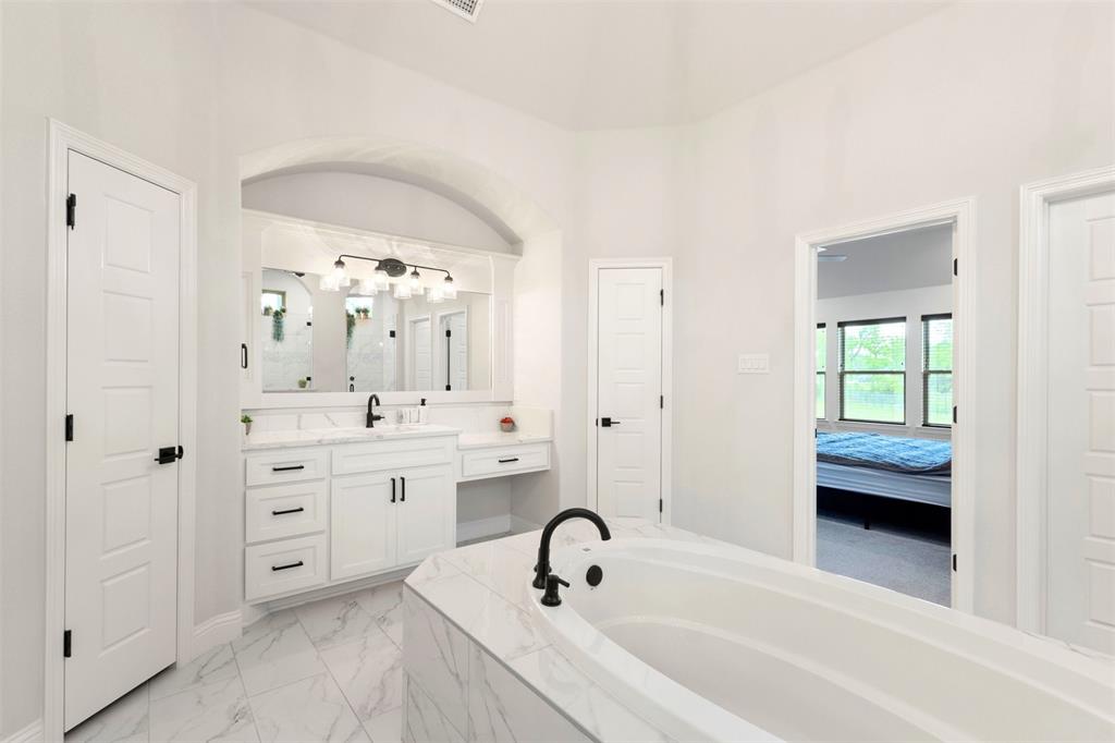105 Clayton Crossing Springtown, TX 76082 - Photo 17 of 40 a spacious bathroom with a tub sink and mirror