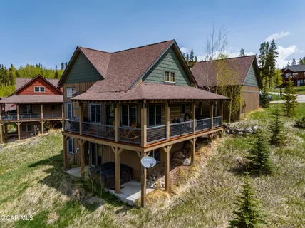 a view of a house with wooden deck front of house