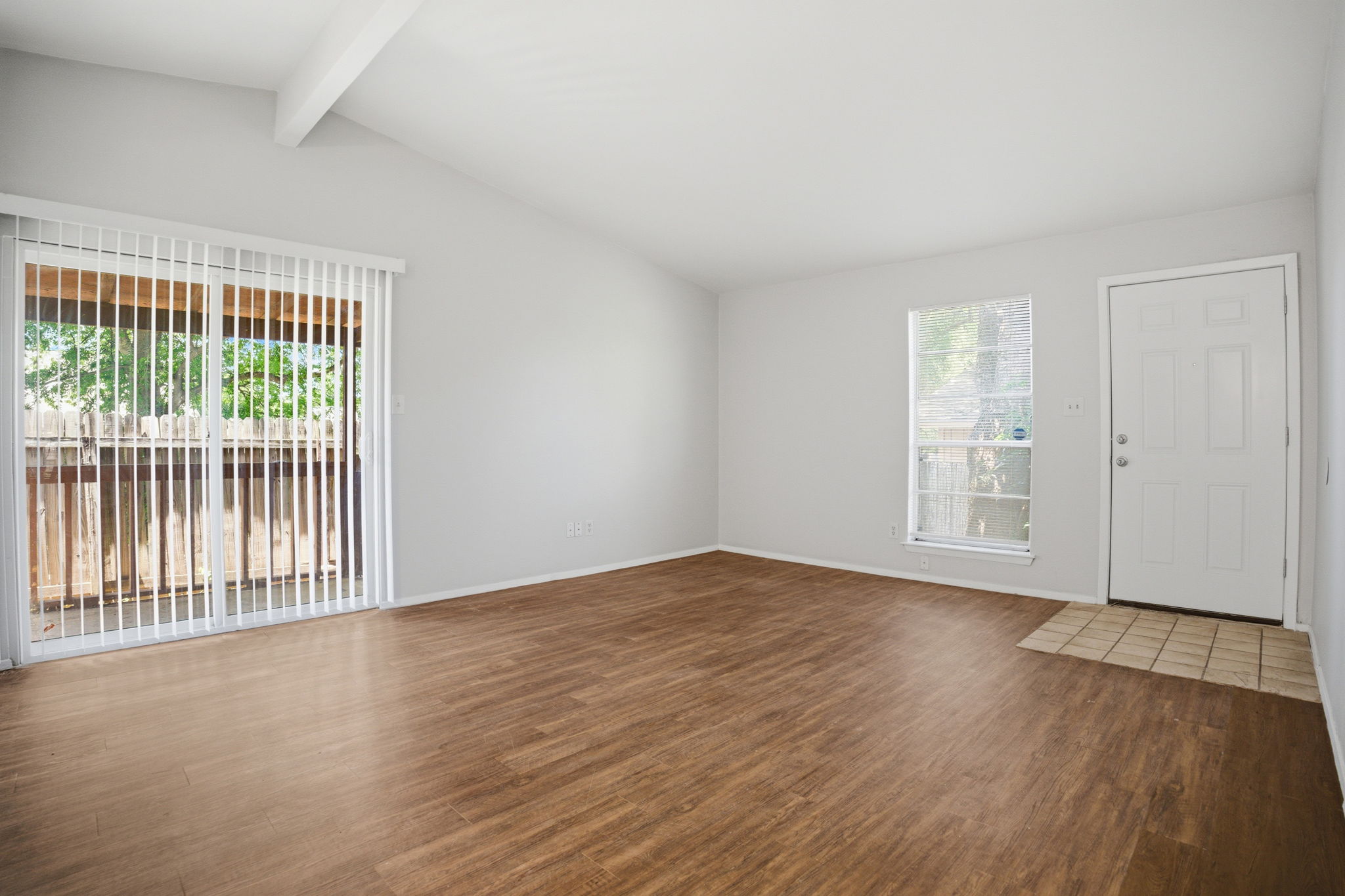 5204 Nuckols Crossing Road, Unit B Austin, TX 78744 - Photo 3 of 16 a view of an empty room with wooden floor and a window