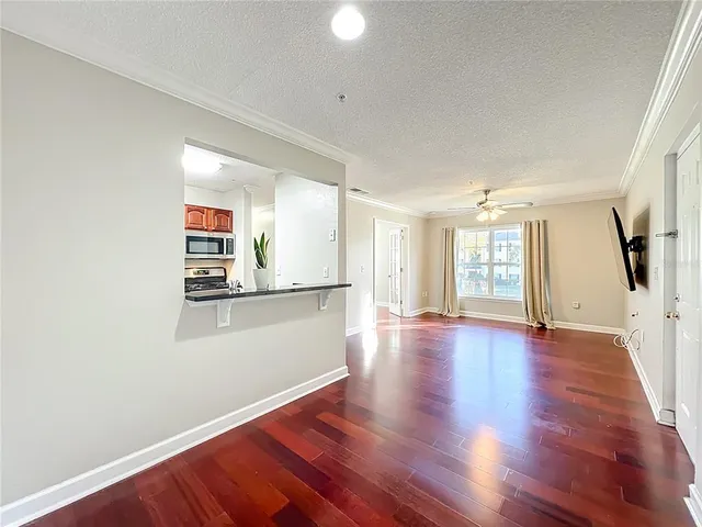 a view of a kitchen with wooden floor and a window