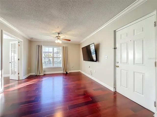 a view of a livingroom with wooden floor and a flat screen tv