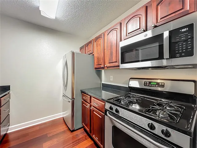 a kitchen with stainless steel appliances granite countertop a stove microwave and refrigerator