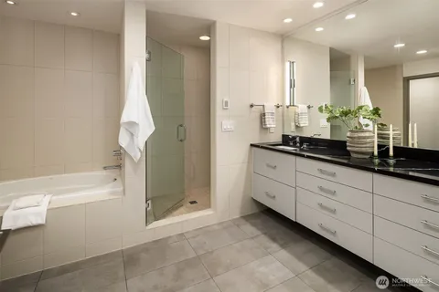 a spacious bathroom with a granite countertop sink a toilet and a bathtub
