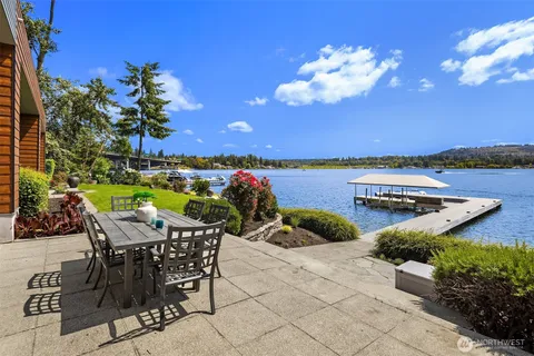 a view of a chairs and table in patio with a lake view