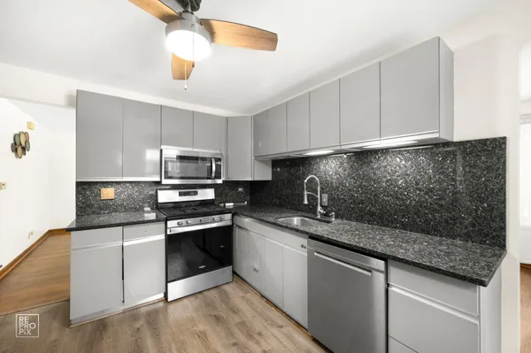 a kitchen with stainless steel appliances granite countertop a sink stove and microwave
