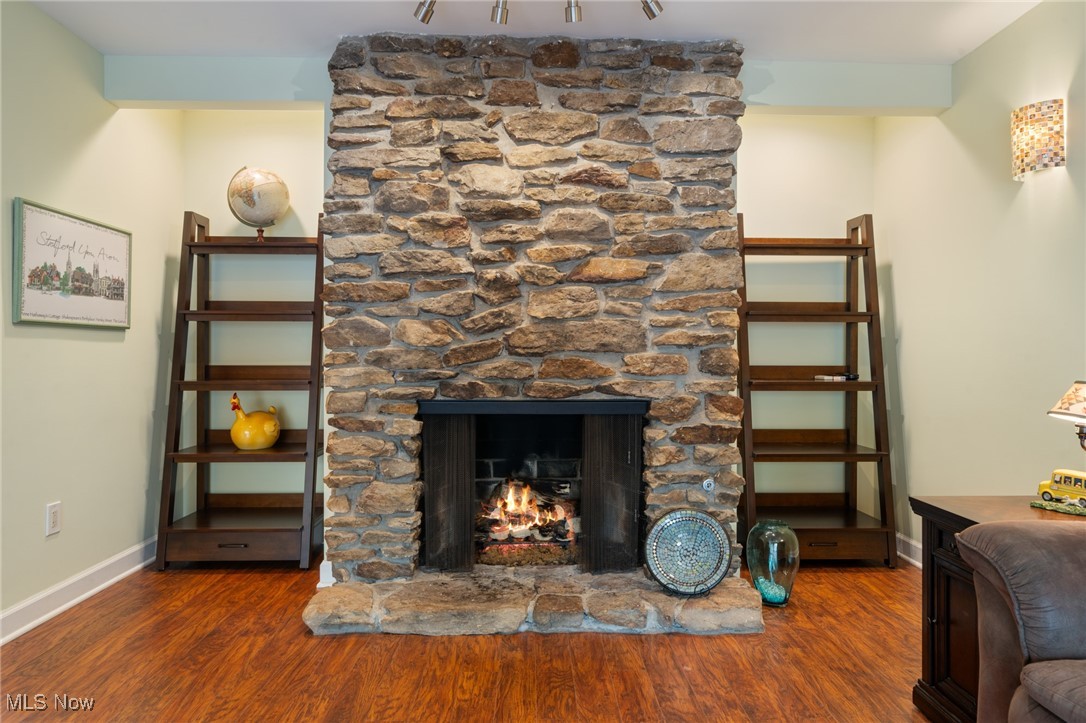17800 Falling Leaves Road Strongsville, OH 44136 - Photo 15 of 39 Family room area with a stone fireplace, baseboards, and wood finished floors