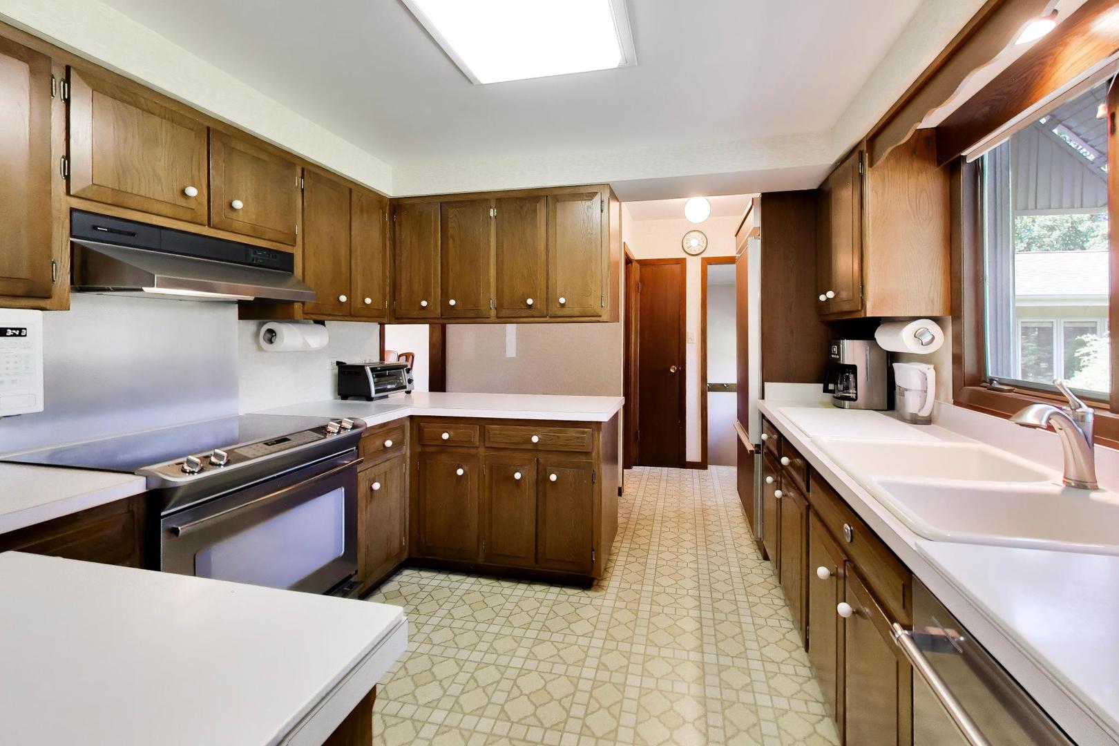 103 Cottonwood Road Northbrook, IL 60062 - Photo 9 of 50 a kitchen with stainless steel appliances granite countertop a sink a stove and a refrigerator