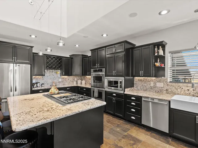 a large kitchen with stainless steel appliances granite countertop a stove and a sink