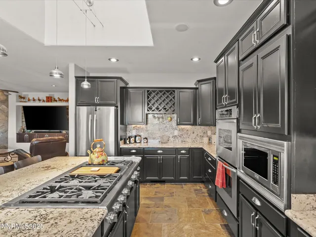 a large kitchen with stainless steel appliances kitchen island granite countertop a large counter top and stove