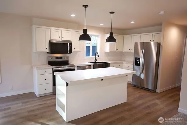 a kitchen with stainless steel appliances a refrigerator sink and microwave