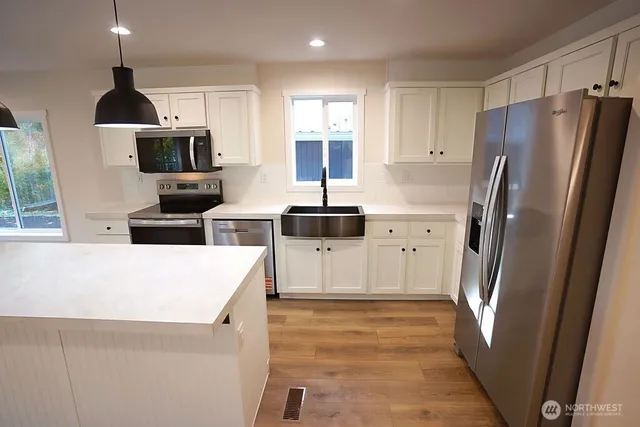 a kitchen with stainless steel appliances a refrigerator stove and microwave